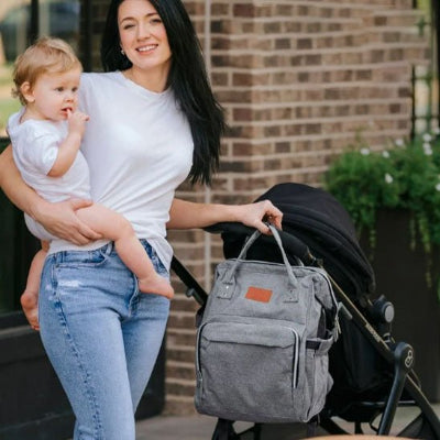 sac à langer à dos maman bébé dans bras sac main poussette